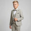 A young boy modeling a light gray three-piece formal suit with a matching bow tie, white dress shirt, and a black pocket square, set against a plain light gray studio background.