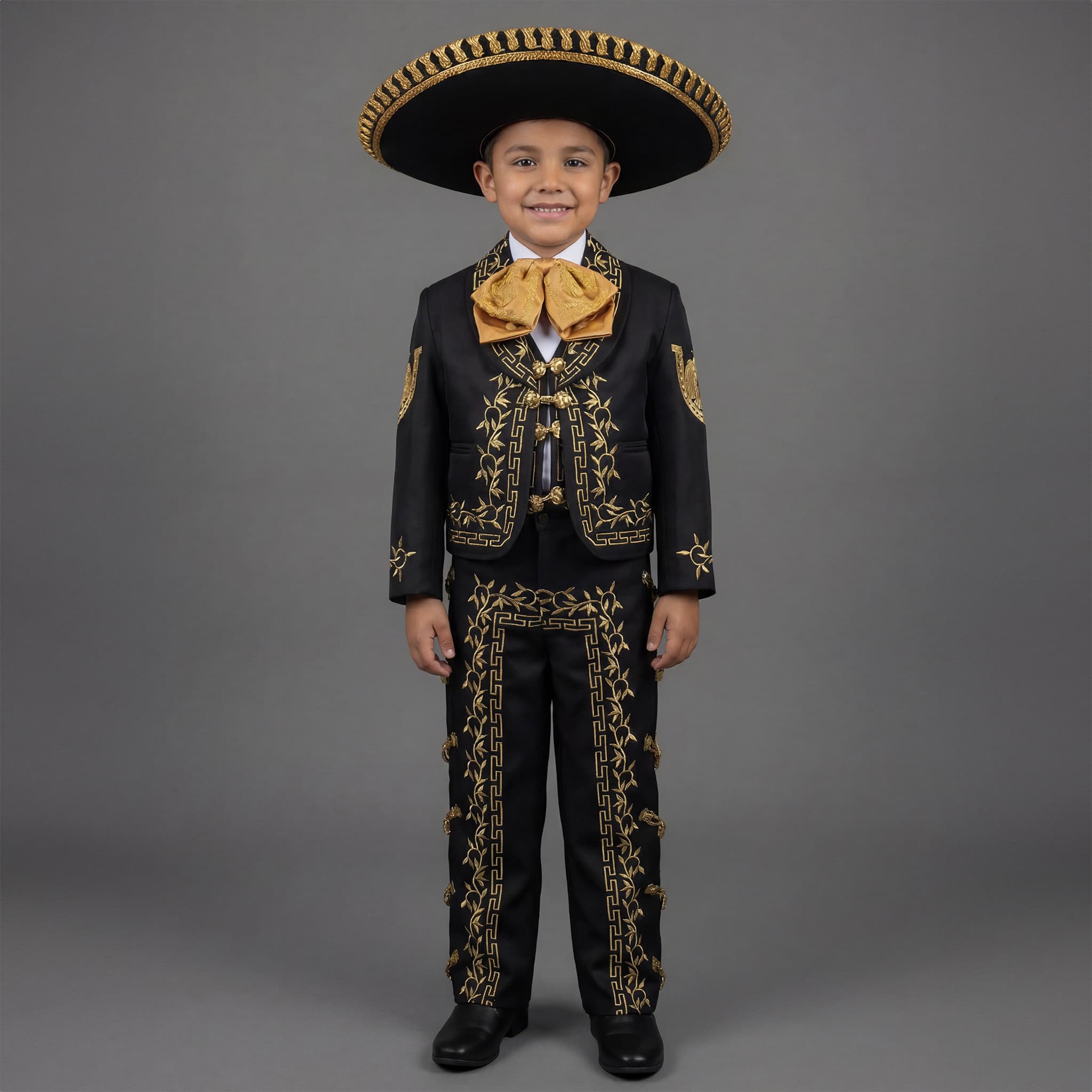 Boy wearing a black and gold charro mariachi suit with gold embroidered horseshoes and horse heads, gold metal buttons, matching sombrero, vest, white shirt, and bow tie. Main image