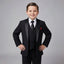 A young boy modeling a black formal three-piece suit with satin lapels, a white dress shirt, a black tie, and a red pocket square, posed against a solid gray studio background.