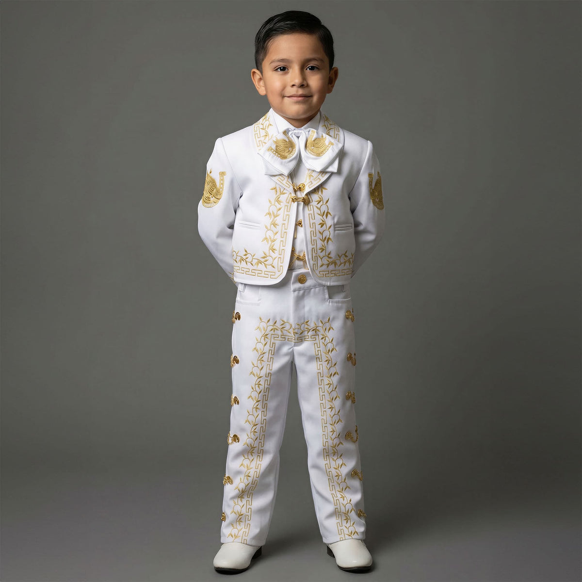 Little boy wearing a white and gold embroidered charro suit with matching sombrero, featuring horseshoe and horse's head embroidery for baptisms, weddings, mariachi performances, and Mexican cultural celebrations. Main image